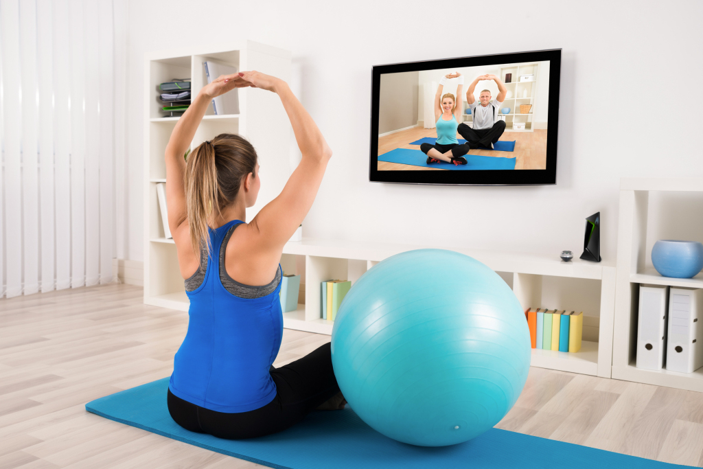 Pregnant Woman Doing Yoga By Watching Television
